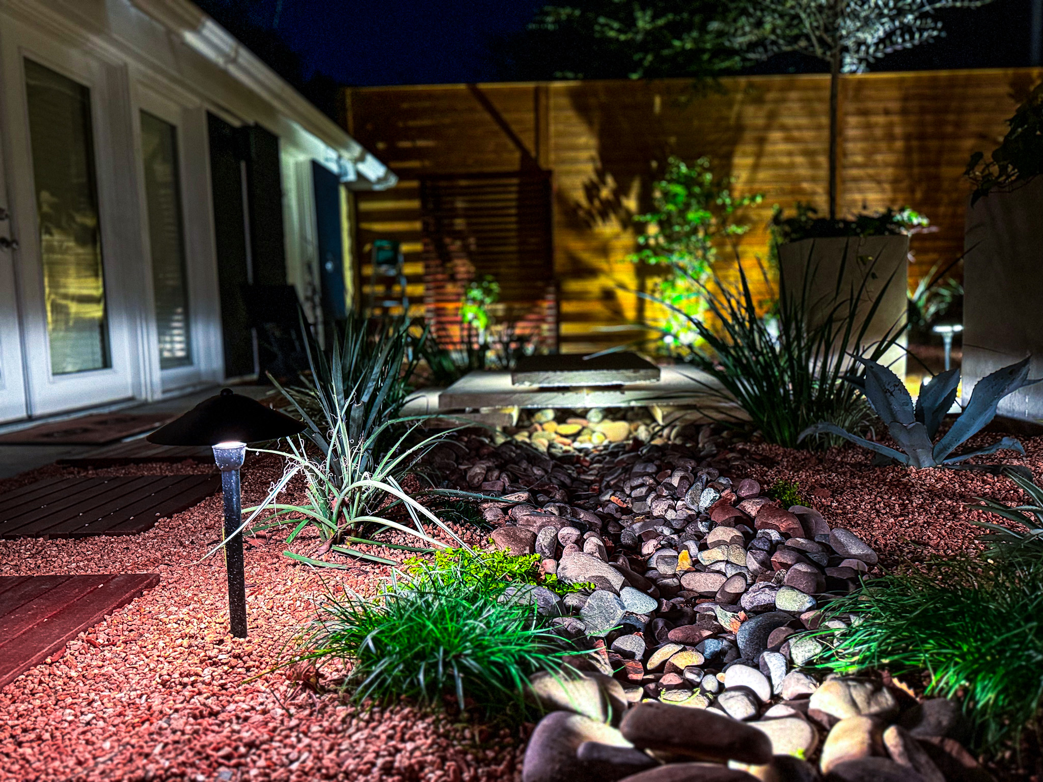 Custom landscape design-build project in Houston with stone pathways and lush planting