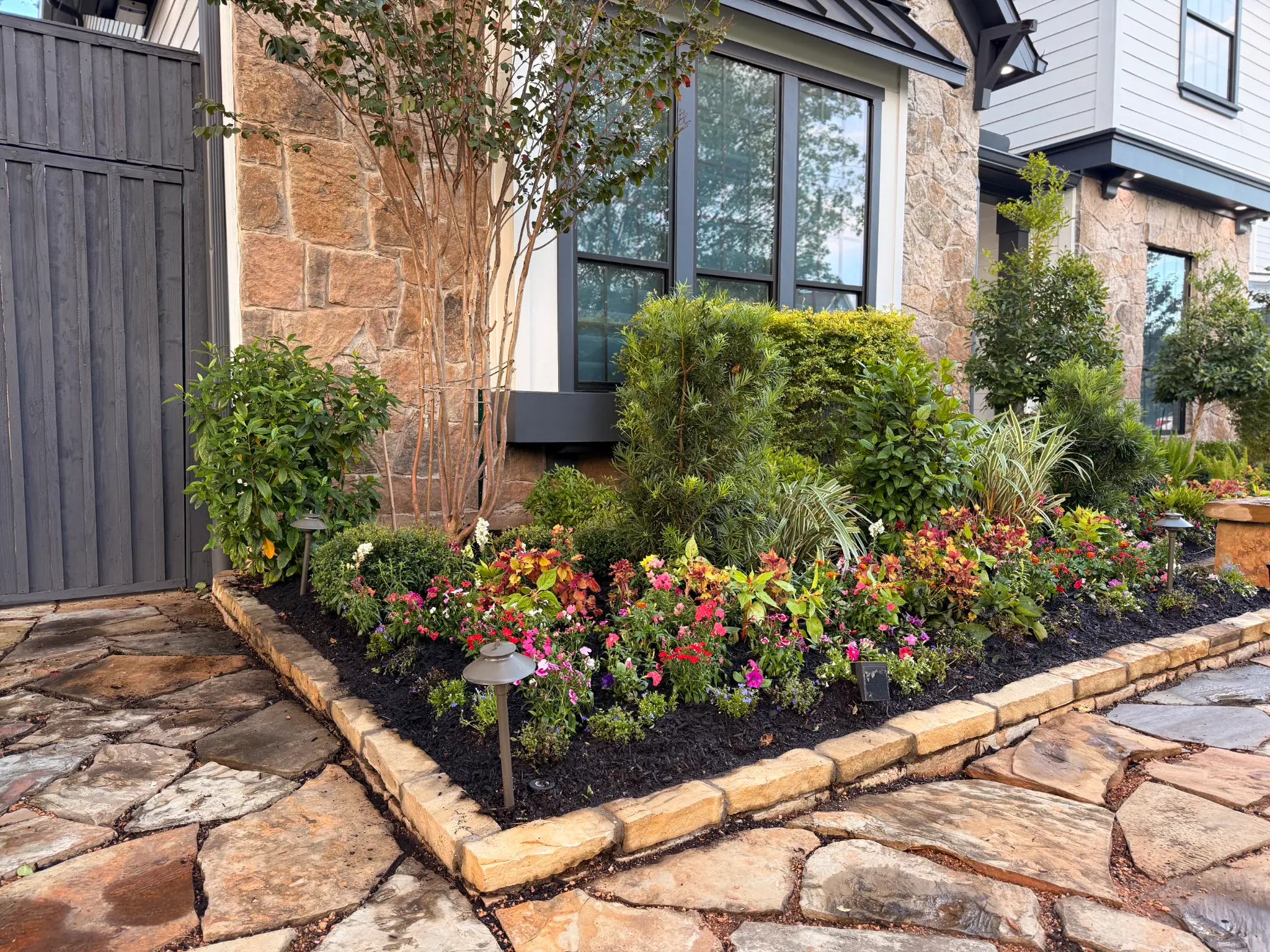 Colorful landscape design with flagstone path and lush planting beds in Houston Texas